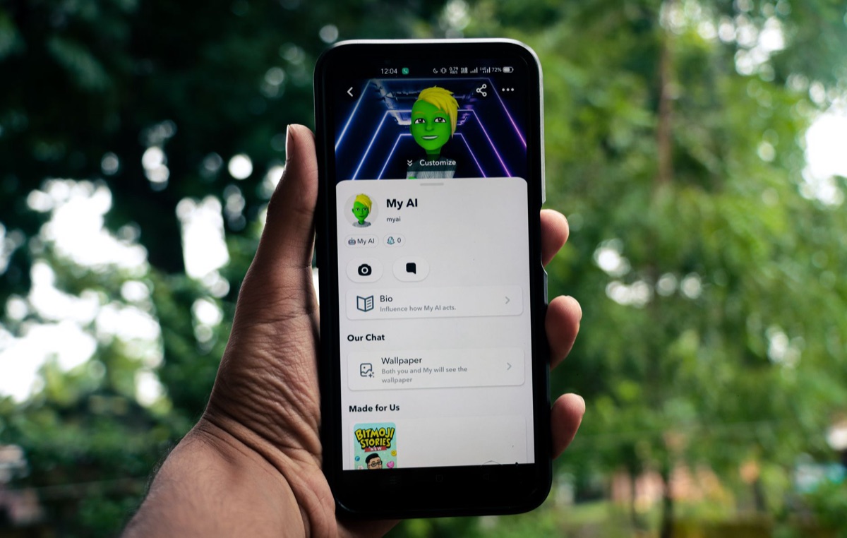 Mãos segurando um smartphone exibindo uma ilustração de personagem de anime.